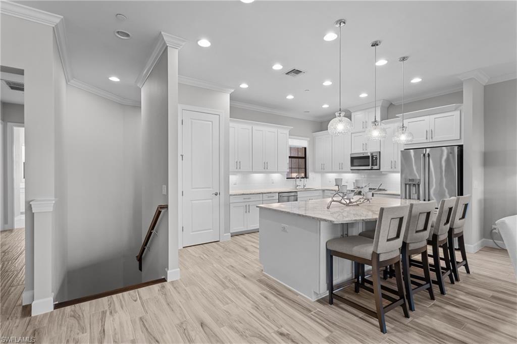 9673 Montelanico Loop, Unit 202 Naples, FL 34119 - Photo 6 of 46 a large kitchen with a table and chairs