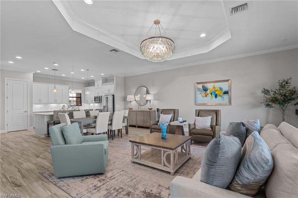 9673 Montelanico Loop, Unit 202 Naples, FL 34119 - Photo 9 of 46 a living room with furniture kitchen view and a chandelier