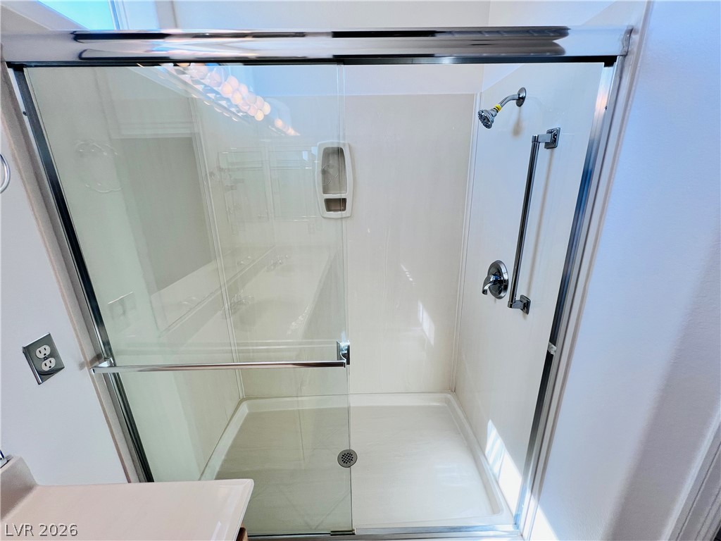 3047 Hickory Valley Road Henderson, NV 89052 - Photo 16 of 33 A well-lit, contemporary shower with clear glass enclosure offers a refreshing daily retreat.