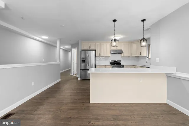 a large kitchen with granite countertop a sink cabinets and stainless steel appliances