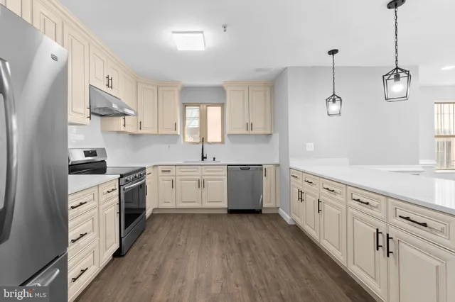 a kitchen with cabinets a sink a window and stainless steel appliances