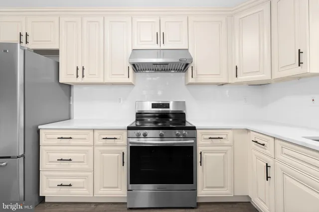 a stove top oven sitting inside of a kitchen