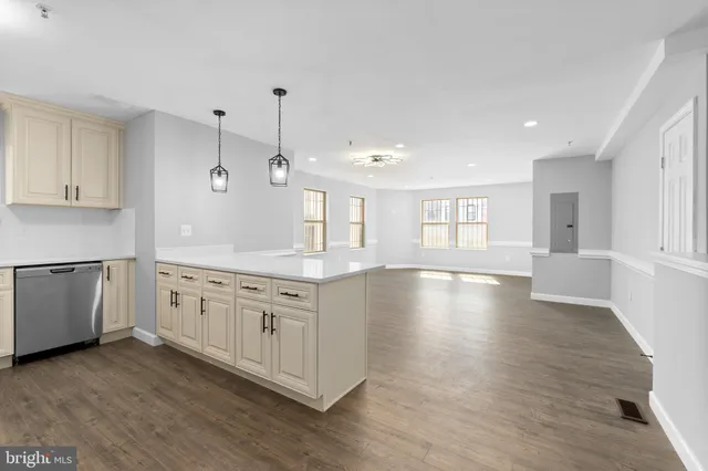 a large kitchen with lot of wooden floors and white cabinets