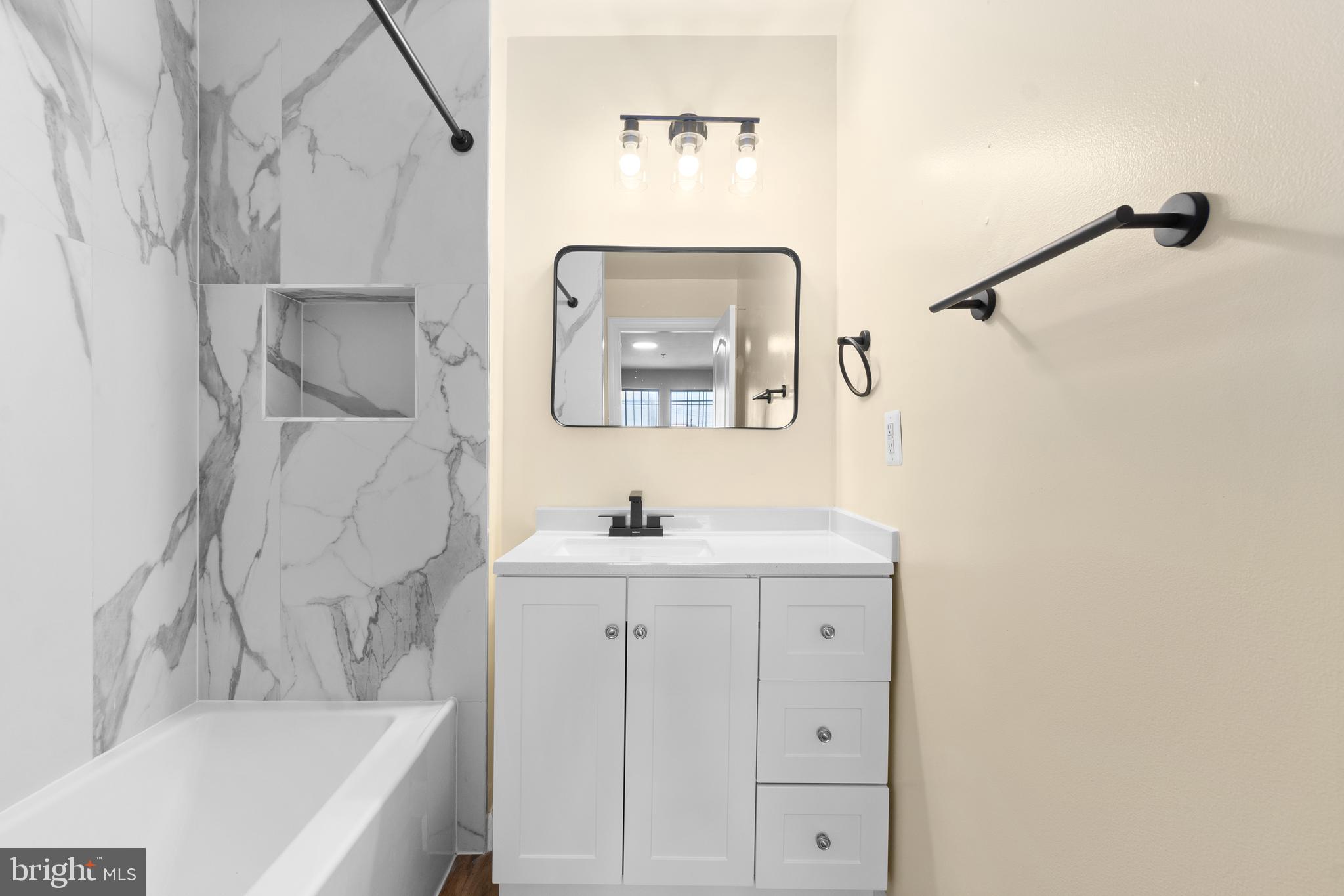 1829 Providence Street Northeast, Unit B Washington, DC 20002 - Photo 18 of 37 a bathroom with a bathtub sink and mirror