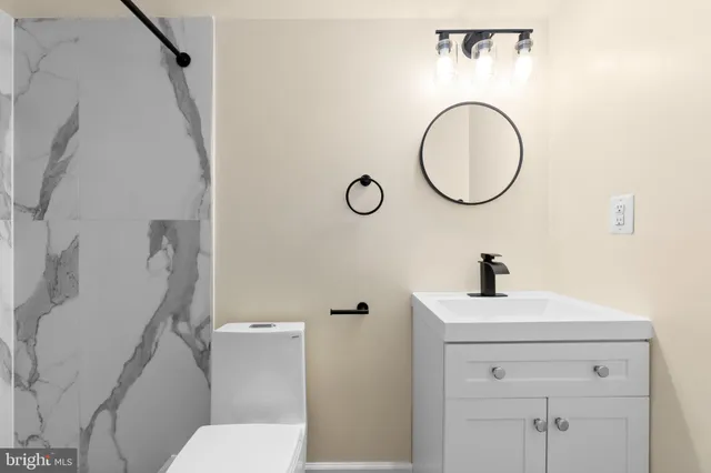 a bathroom with a toilet sink and mirror