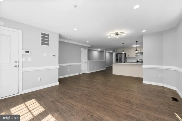 a view of a kitchen with wooden floor and windows