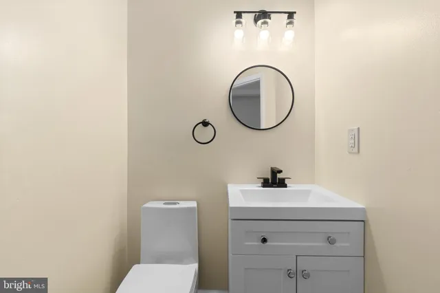 a bathroom with a sink a toilet and a mirror
