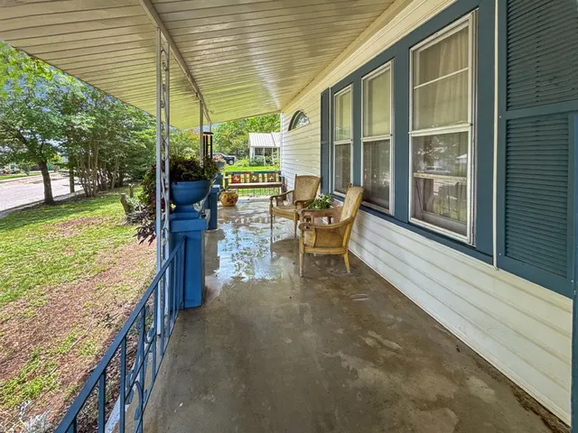 a patio with table and chairs and potted plants