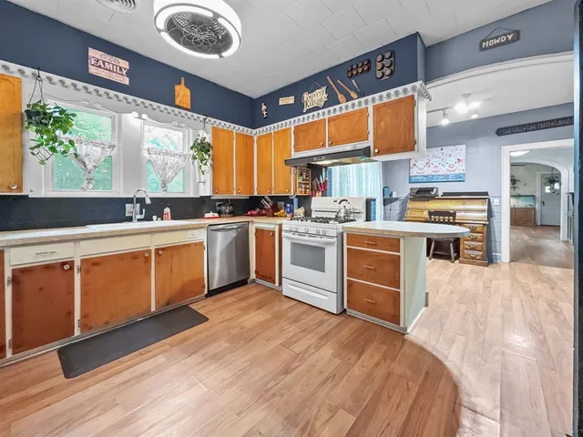 a kitchen with stainless steel appliances granite countertop a stove a sink and a microwave