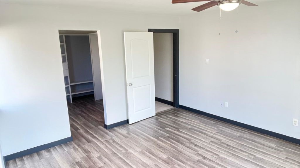 5606 Lyden Ridge Drive Houston, TX 77053 - Photo 33 of 34 an empty room with wooden floor a ceiling fan and windows