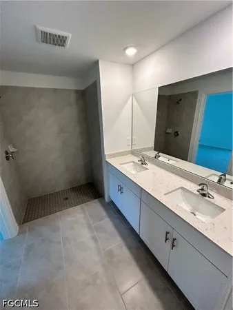a bathroom with a double vanity sink and mirror