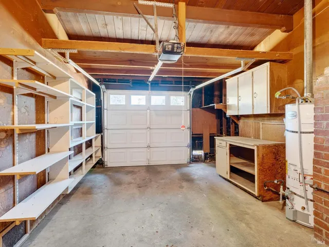 a view of a backyard with wooden fence and a large tree