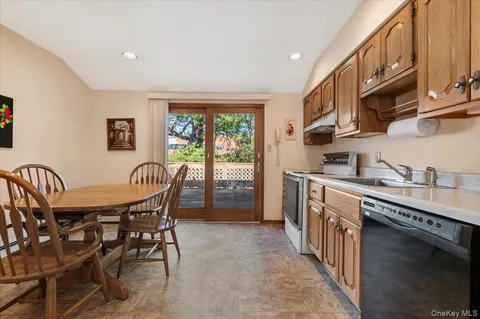 a kitchen with stainless steel appliances granite countertop a table chairs sink and cabinets