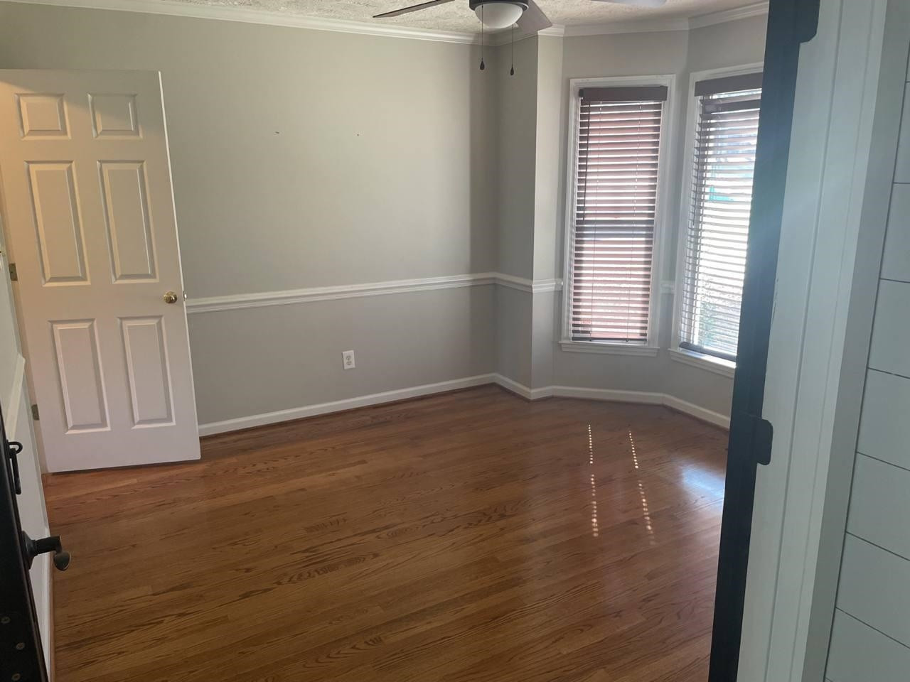 7818 Shuttle Road Fayetteville, NC 28311 - Photo 9 of 21 an empty room with wooden floor and windows with curtains