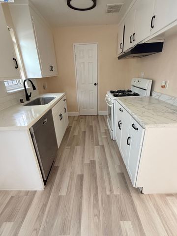 a kitchen with sink a stove and cabinets