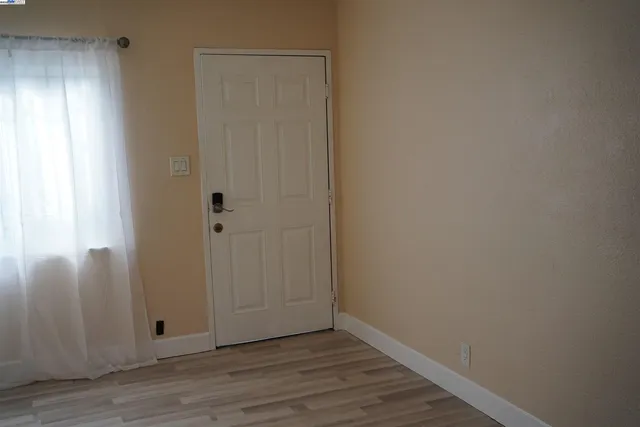 a view of an empty room with wooden floor