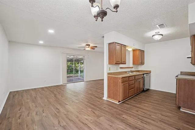 a kitchen with granite countertop a stove and a wooden floors