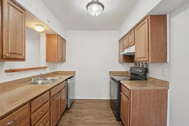 a kitchen with stainless steel appliances granite countertop a sink stove and cabinets