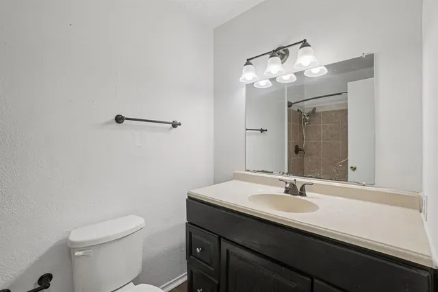 a bathroom with a sink a toilet a mirror and shower