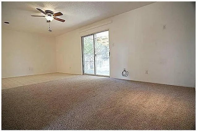 a view of a big room with windows and chandelier fan