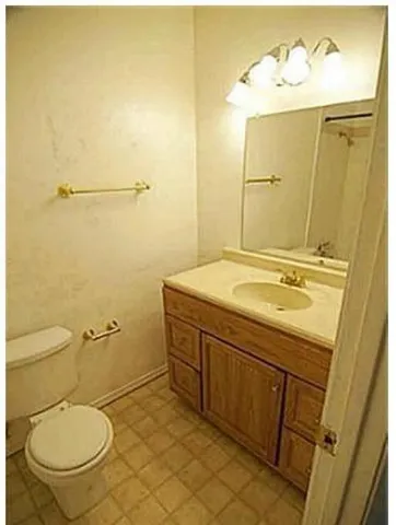 a bathroom with a granite countertop toilet sink and mirror