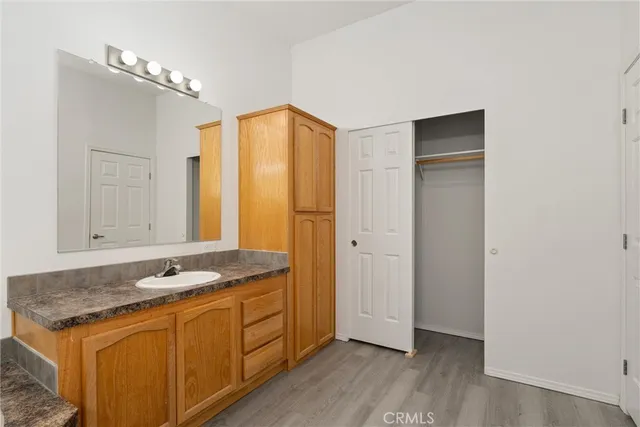 a view of a kitchen with granite countertop window sink and cabinets