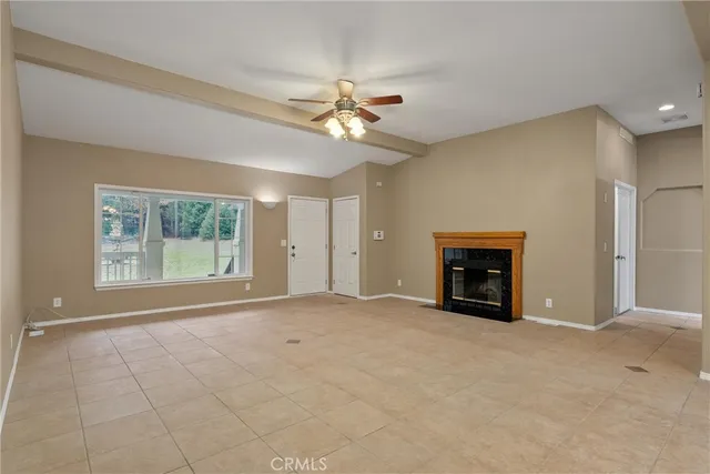 an empty room with windows and ceiling fan