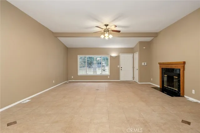 an empty room with windows and fireplace