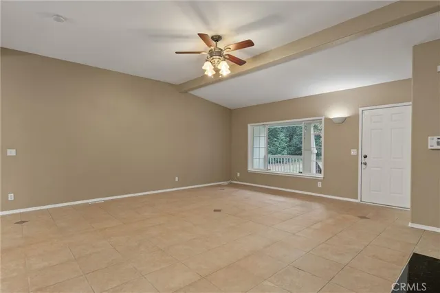 an empty room with windows and ceiling fan
