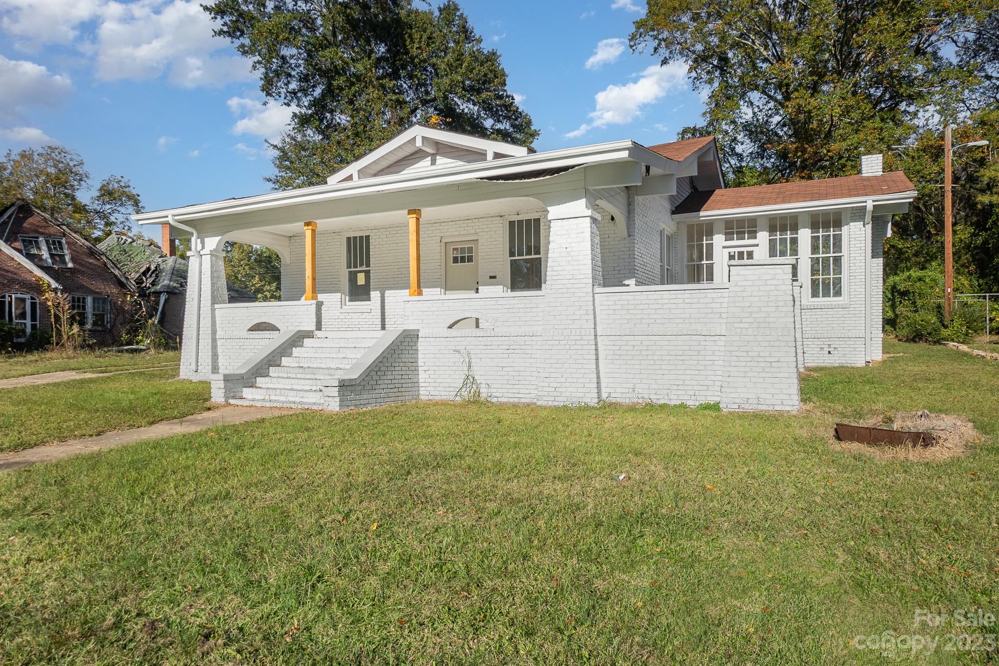 a view of a yard in front of a house with large windows