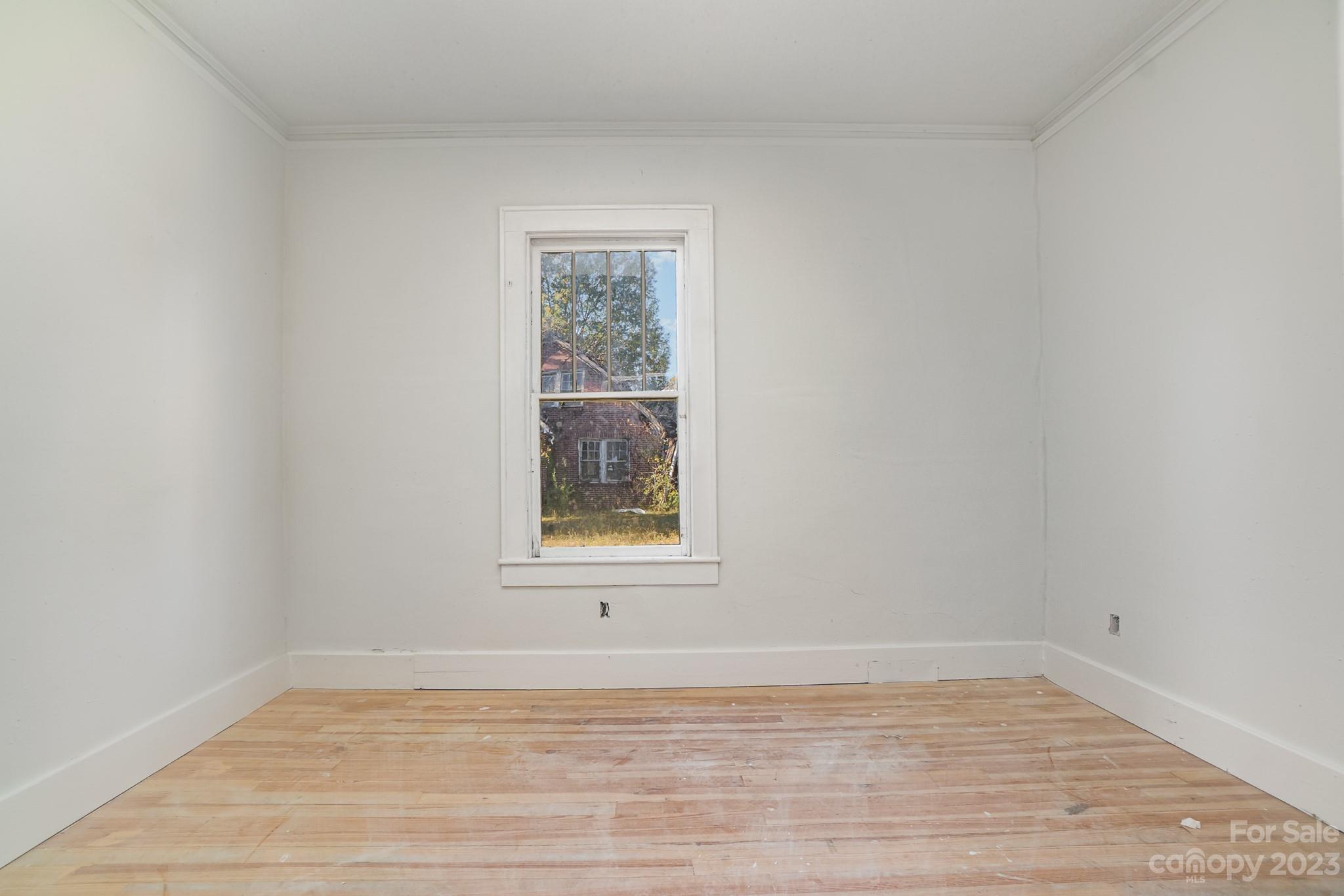 113 Brawley Street Chester, SC 29706 - Photo 19 of 29 a view of an empty room with a window and wooden floor