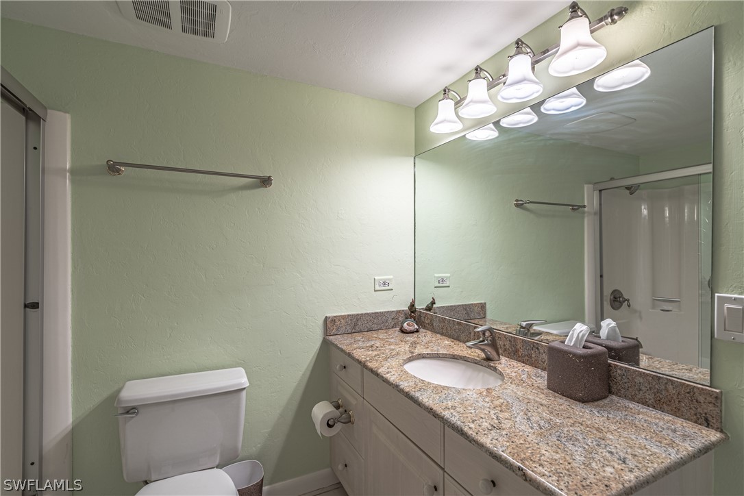 124 Useppa Island Bokeelia, FL 33922 - Photo 11 of 30 a bathroom with a granite countertop sink a toilet and a mirror