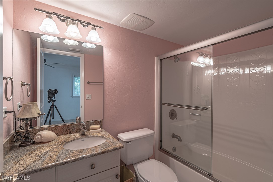 124 Useppa Island Bokeelia, FL 33922 - Photo 13 of 30 a bathroom with a granite countertop sink toilet and shower