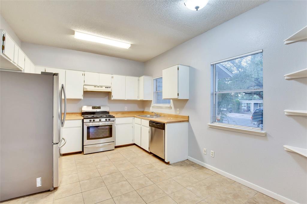 3113 Robinson Avenue, Unit B Austin, TX 78722 - Photo 5 of 16 a kitchen with white cabinets and appliances