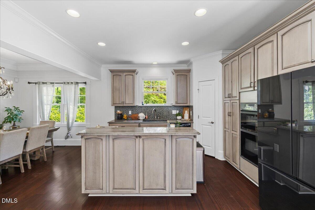 1304 Flying Hawk Road Apex, NC 27523 - Photo 12 of 52 a kitchen with kitchen island granite countertop a sink cabinets and stainless steel appliances