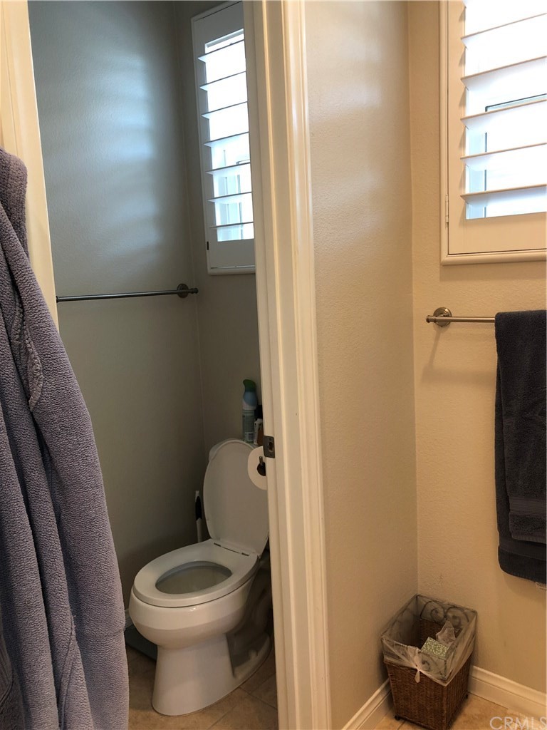 303 Canoe Pond Costa Mesa, CA 92627 - Photo 37 of 49 a white toilet sitting next to a bathroom sink and a window
