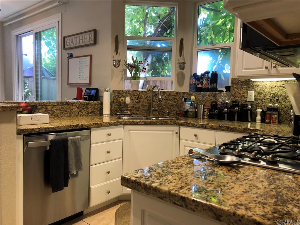 303 Canoe Pond Costa Mesa, CA 92627 - Photo 5 of 49 a kitchen with stainless steel appliances granite countertop a stove a sink and a microwave