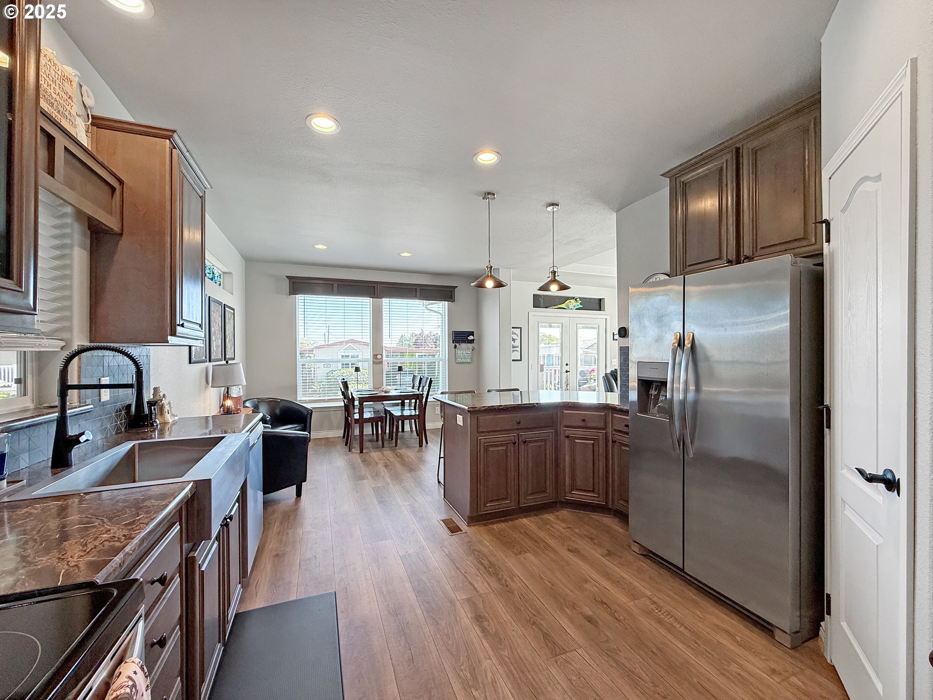 15889 Sunset Strip, Unit 44 Brookings, OR 97415 - Photo 14 of 44 a kitchen with stainless steel appliances granite countertop a refrigerator a stove top oven a sink dishwasher and white cabinets with wooden floor