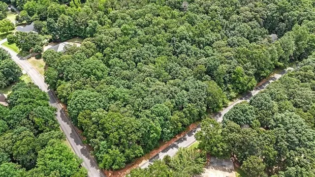 an aerial view of residential house with outdoor space and trees all around