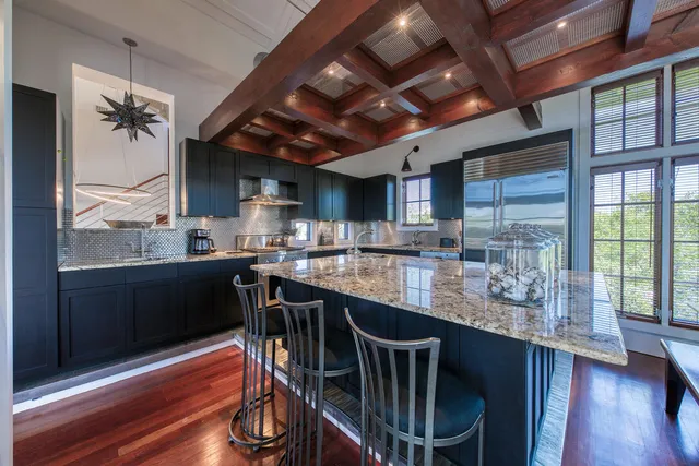 a kitchen with stainless steel appliances granite countertop a table chairs and wooden floor