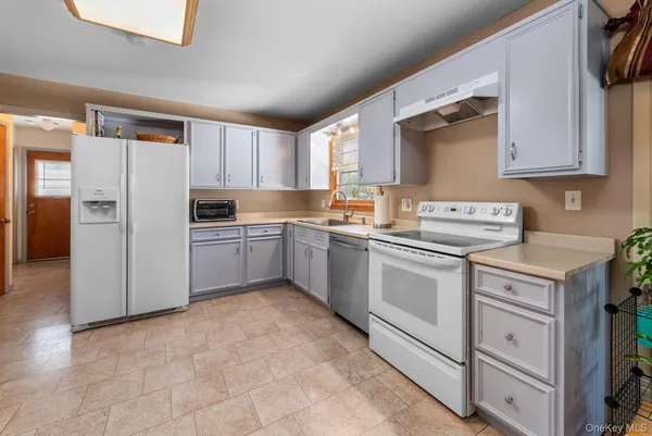 a kitchen with stainless steel appliances granite countertop a refrigerator sink and cabinets