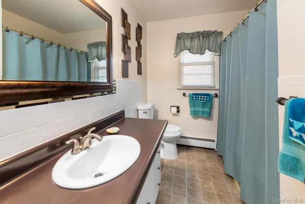 a bathroom with a sink a toilet and a mirror