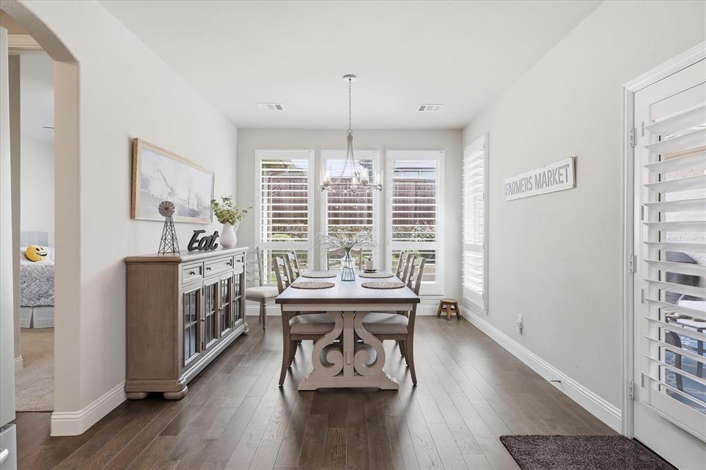 9708 Surveyor Road Oak Point, TX 75068 - Photo 8 of 34 Dining area featuring wood-finish flooring, white plantation shutters, a contemporary chandelier, and recessed lighting