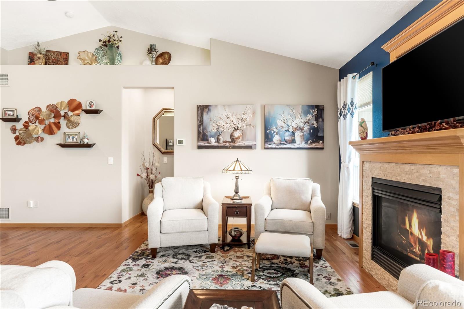 2013 Trail Ridge Drive Severance, CO 80615 - Photo 6 of 49 a living room with furniture a flat screen tv and a fireplace