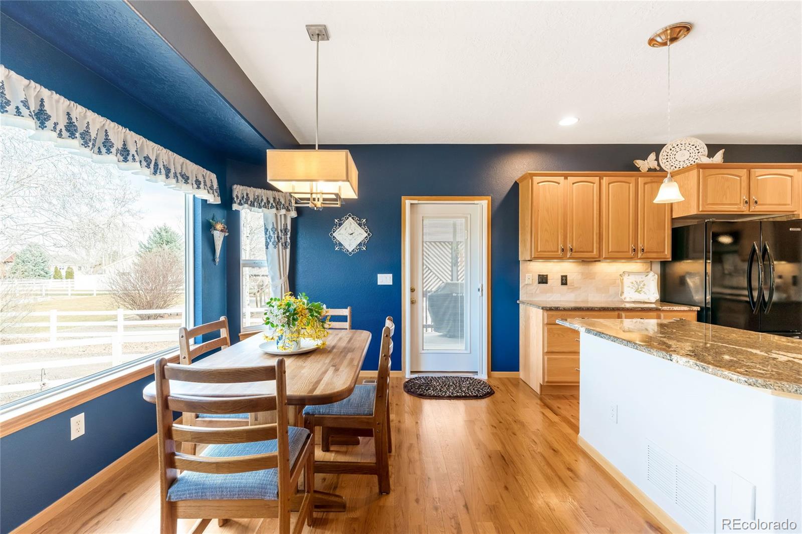 2013 Trail Ridge Drive Severance, CO 80615 - Photo 8 of 49 a kitchen with a stove a refrigerator and a dining table with wooden floor