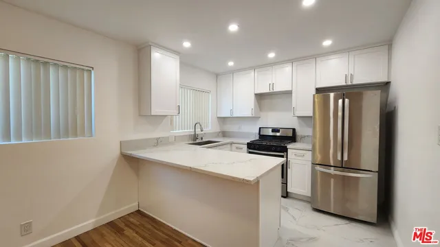 a kitchen with kitchen island a sink appliances and cabinets
