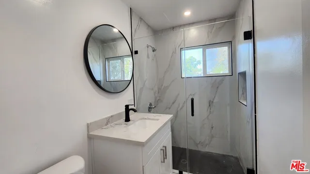 a bathroom with a toilet sink and mirror