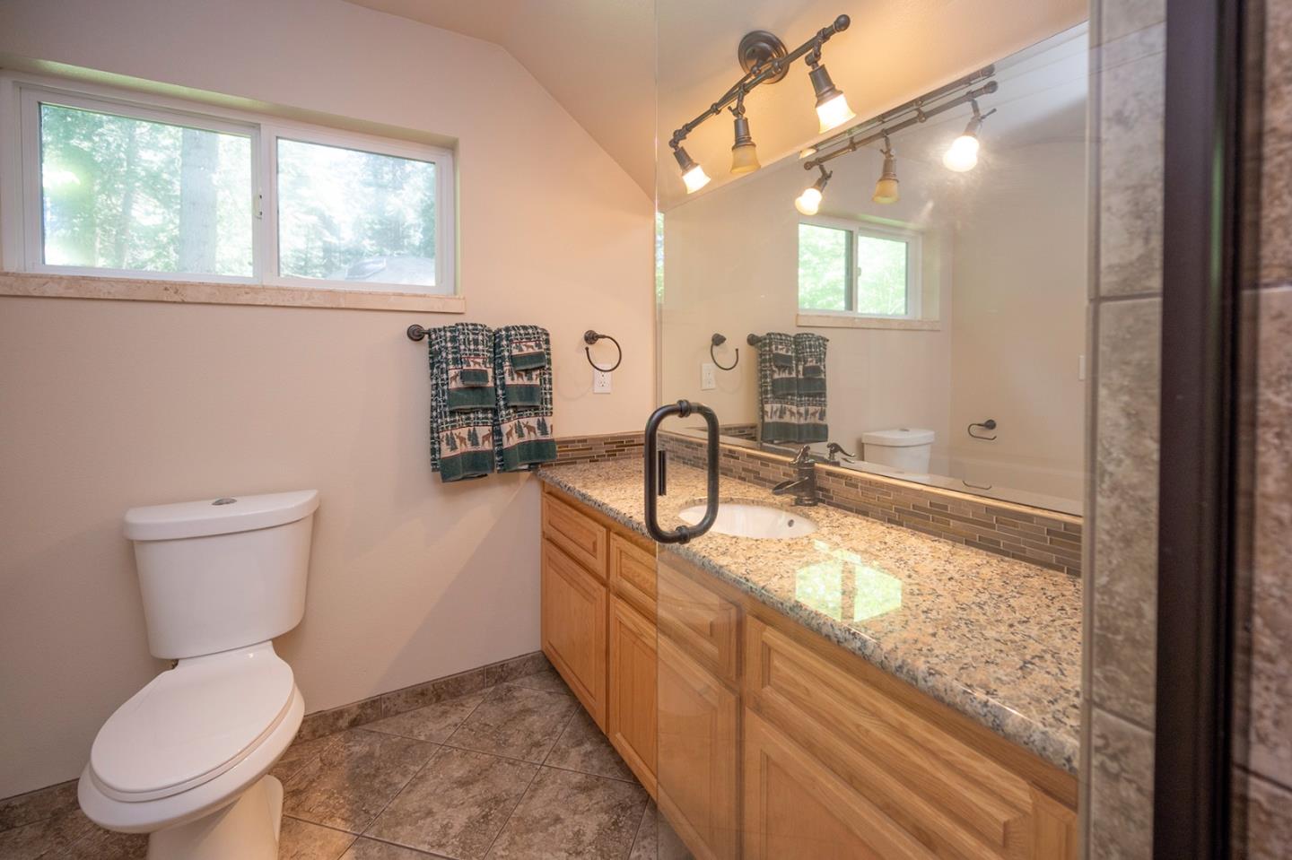 2271 Murphys Drive Arnold, CA 95223 - Photo 64 of 91 a bathroom with a granite countertop toilet a sink and a large mirror