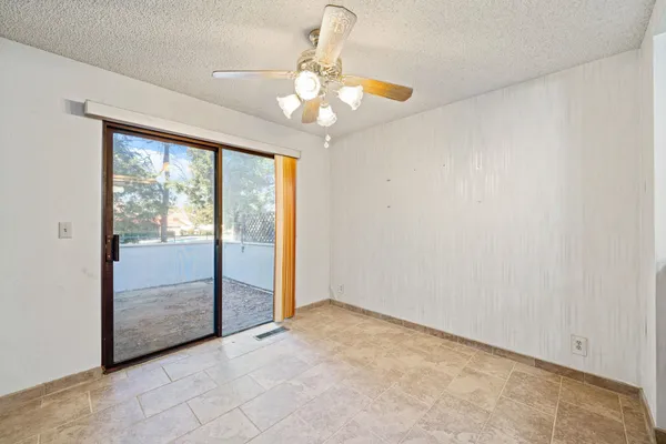 a view of a livingroom with a chandelier fan and windows