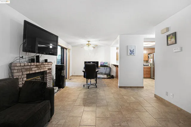 a living room with furniture kitchen view and a flat screen tv